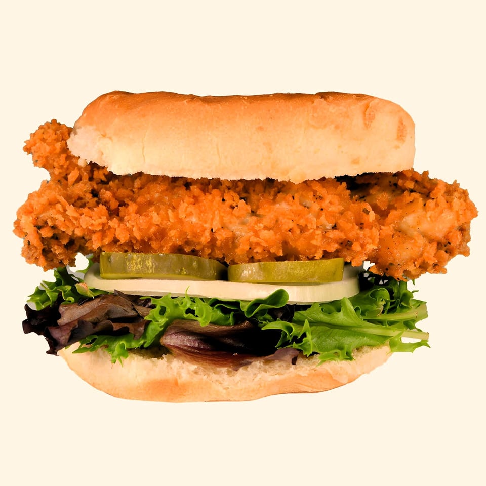 M2 Burger's crispy chicken sandwich with lettuce, onions, and pickles on a bun.