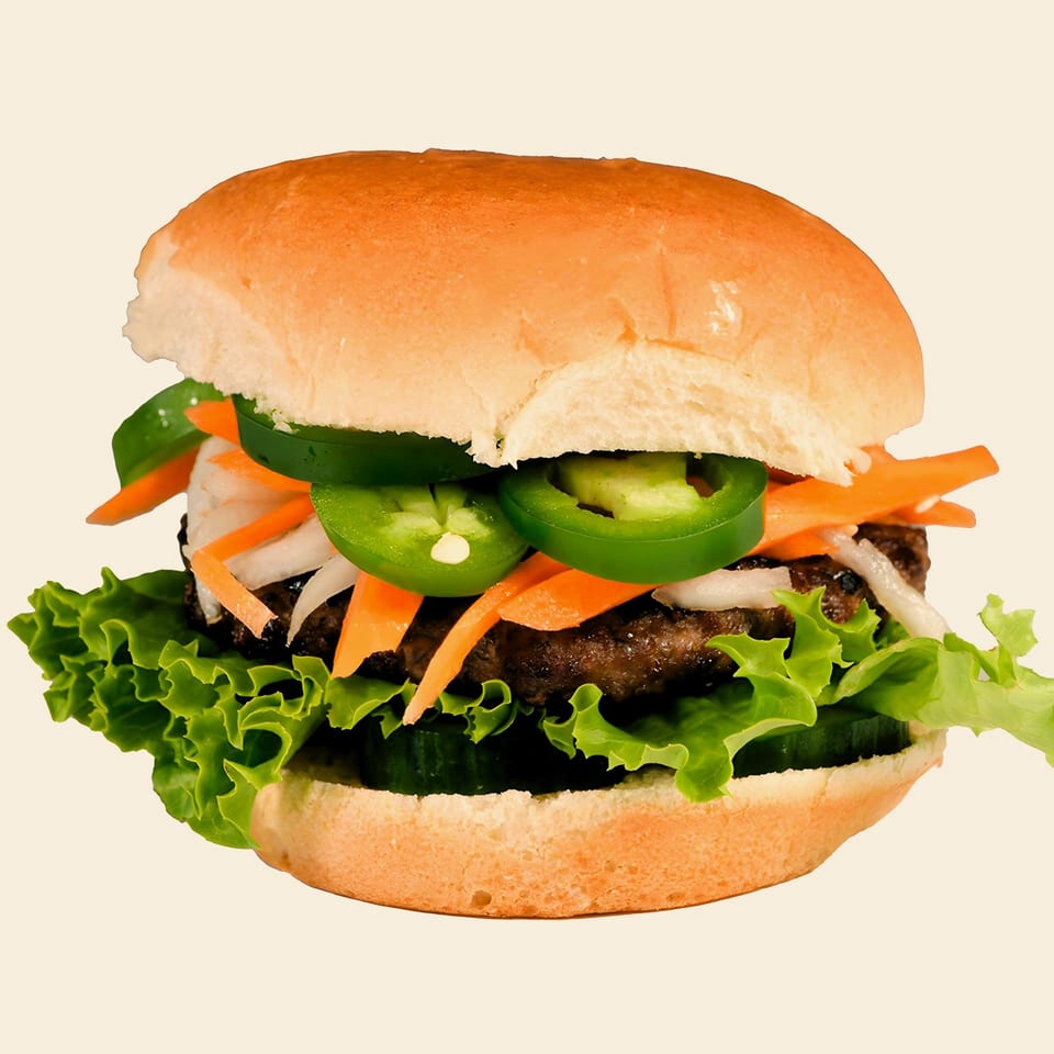 M2 Burger with a patty, lettuce, cucumbers, shredded carrots, onions, and sliced jalapeños.